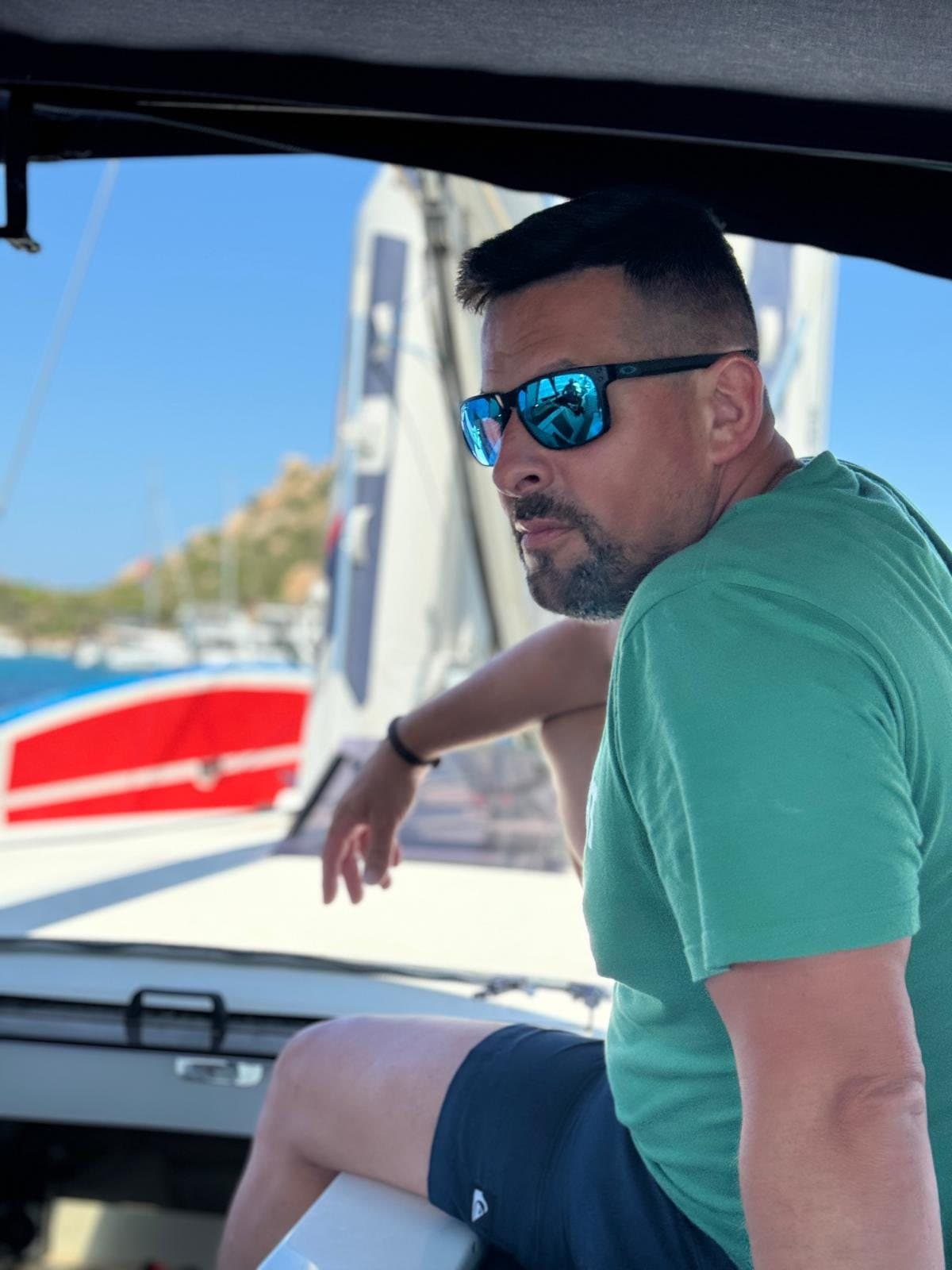 Sergio Cogolludo a bordo, con gafas de sol y camiseta verde